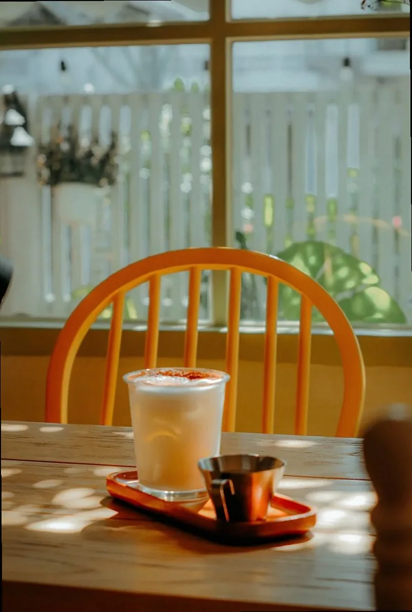 A refreshing milkshake on a sunlit table in a cozy cafe setting.
